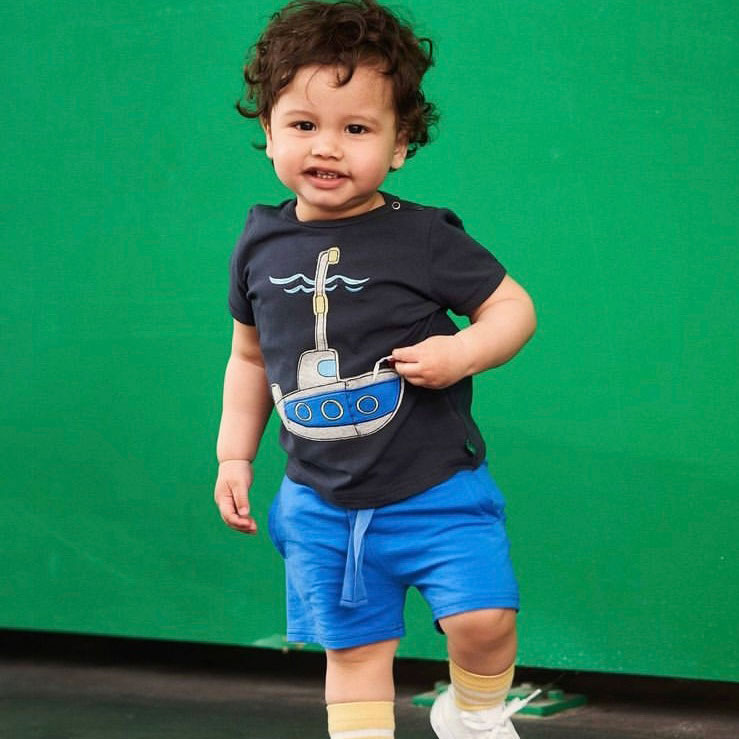 Toddler wearing a and organic shirt and blue pants